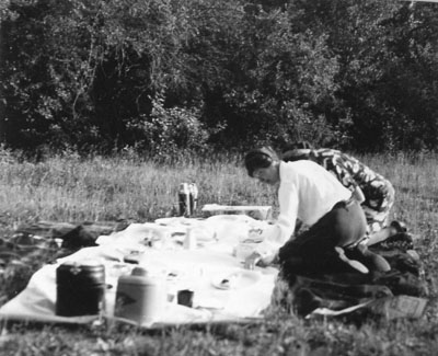 Two women placing dishes out for a picnic