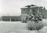 Linfield Hall and glass greenhouses at Montana State University in the snow. February 1913