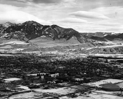 Aerial view from the southwest of campus with the Bridgers in the background in the snow, 1958.