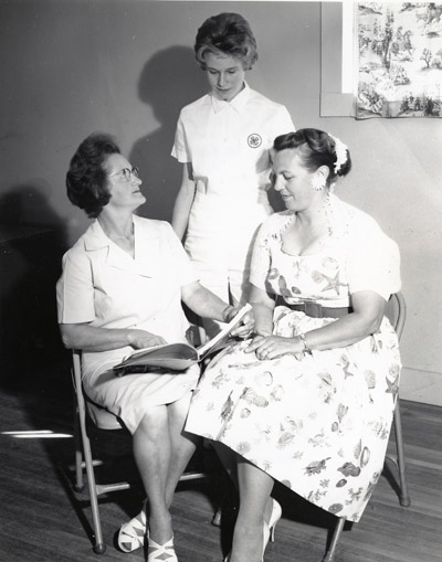 Mrs. John Lockie, Mrs. Arlo Nansel and Charlene Stevens check the Miles City, Montana 4-h Club Record books.