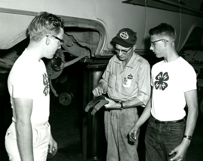 Thomas Miller shows Roy Day and Dennis Bradshaw a New and a Worn Brake Shoe.