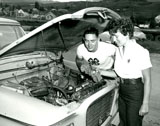 Dale Webster Watches Eileen Dutton as she Checks the Water Level in the Radiator of Her Car