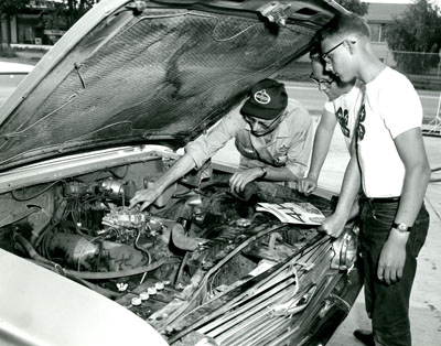 Thomas Miller, from Billings, Montana, Explains the Operation of the Carburetor to Roy Day and Dennis Bradshaw