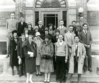 A Group photo of Young Men and Women Standing on the Stairs to a Building.