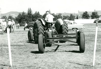 A Young Man Backs up a Tractor and Trailer Between Two Posts.