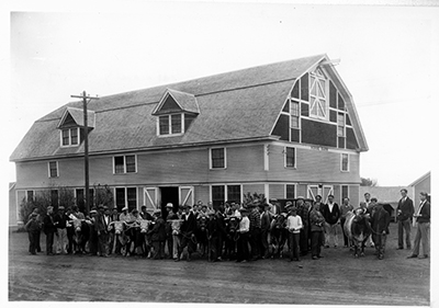 Group with cattle in front of the Horse Barn
