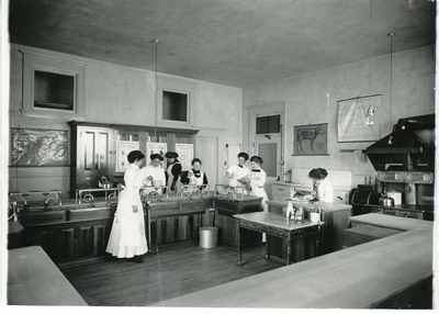 Women work on their cooking skills in a Home Economics class, 1916