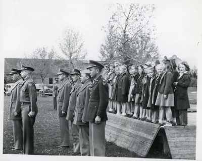 ROTC members standing in front of a group of children