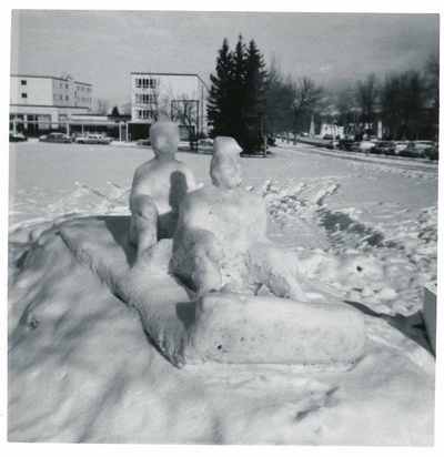 Snow sculpture of two figures on a sled