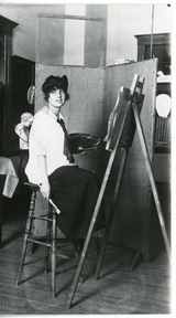 Woman sitting in front of an easel