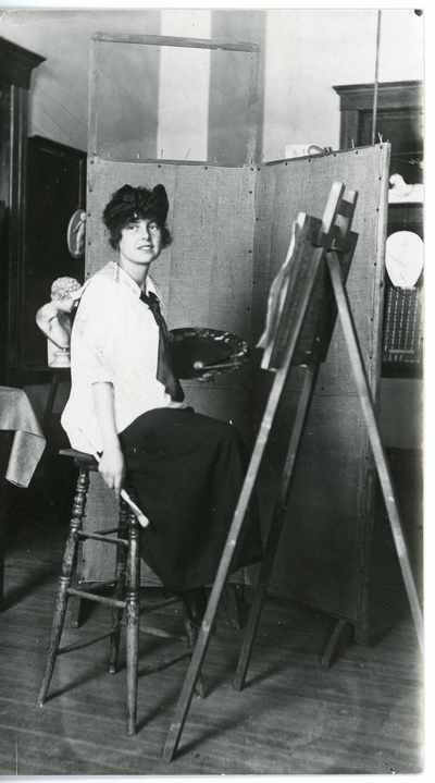 Woman sitting in front of an easel