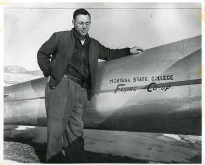 Man standing next to the Montana State College Flying Co-op plane
