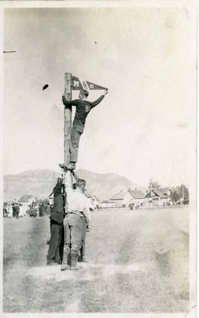 Students climbing flag pole, 1919