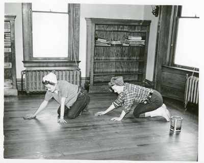Two women staining a floor