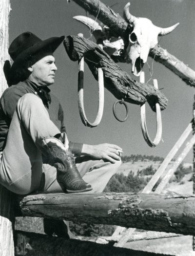 Cowboy sitting on a fence