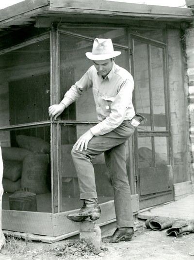 Cowhand Scraping Mud off His Boots, Quarter Circle U Roundup, Montana