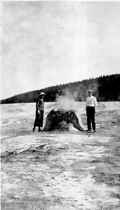 a man & woman examine a geyser cone - Yellowstone National Park