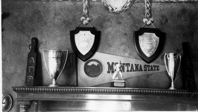 Mantle displaying awards, trophies, Alpha Gamma Rho, Montana State College