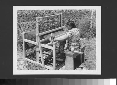 An Arapaho Woman Weaving on a Floor Loom Outside