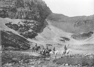 Photo of 5 people riding on horseback through Glacier National Park
