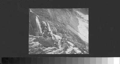Photo of a group of people at a waterfall in Glacier National Park