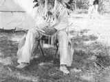 Bernadotte: Blackfeet Indians: Man in Full Indian Dress Sitting on a Metal Folding Chair, 1939