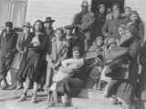 Photo of a large group of men and women outside a building dressed in winter clothes, Browning, Montana