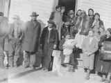 Photo of men, women and children dressed in winter clothes, Browning, Montana