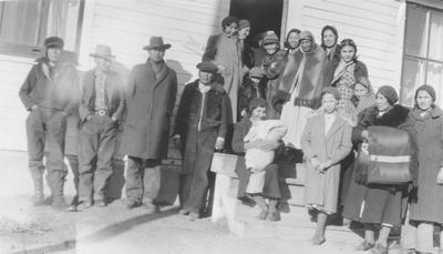 Photo of men, women and children dressed in winter clothes, Browning, Montana