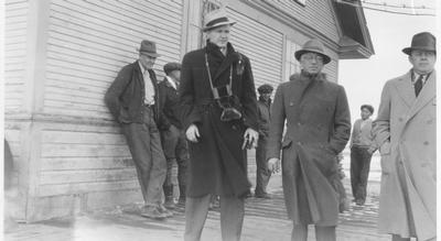 Black and white photo of Technicians standing outside the train depot.