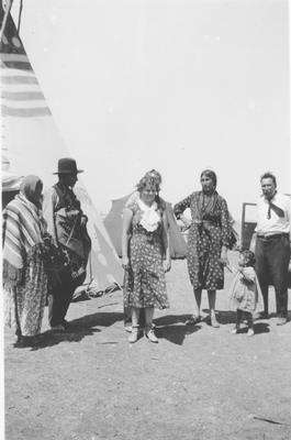 Black and white photo of a group of people including Mrs. Middle rider, Mr. Middle Rider, Bird Rattle, Cecile By and Oscar Boy, Browning, Montana, 1935