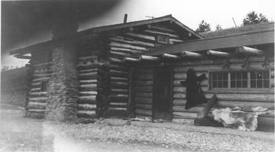 Black and white photo of the outside of the craft shop, with animal skins stretched on the walls, Saint Mary