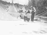 Black and white photo of 4 men painting and assembling tipis, Saint Mary's, Montana