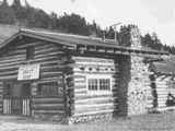 Black and white photo of the log building craft shop in Saint Mary's, Montana