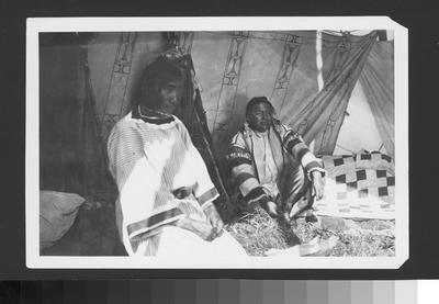 Black and white photo of Short Face and Sad Eyed inside of a tipi