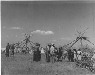 Black and white photo of men and women erecting the lodge for the Sun Lodge Ceremonies in Browning, Montana, 1927
