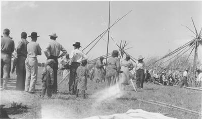 Black and white photo of people setting up tipis for the Sun Lodge Ceremonies, Browning, Montana, 1927