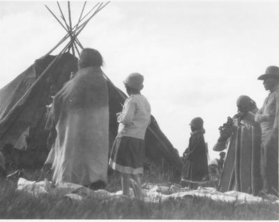 Black and white photo of a group of men and women taking a vow during the Sun Lodge Ceremonies, 1927