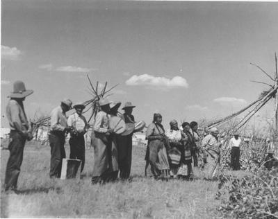 Black and white photo of a group of people drumming during the Sun Lodge Ceremonies, Browning, Montana,1927
