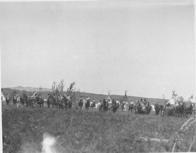 Black and white photo of a very large crowd heading back to camp from the sweat lodge, during the Horn Society Sun Lodge ceremonies, 1927