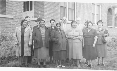 Photo of a group of men and women standing in front of a brick building for the North Plains Craft Association