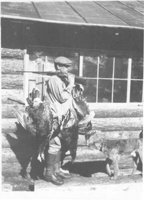 Man Holding a Gun and Three Turkeys Over His Shoulder After Hunting, 1918