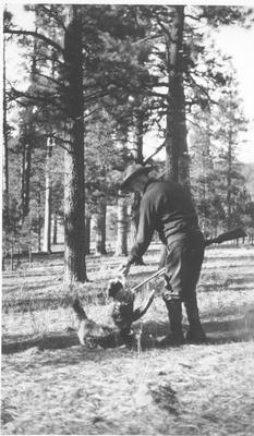 An Elderly Man Holds A Turkey and Allows a Cat to Smell It