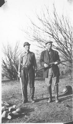 Two Men in Hunting Clothes Holding Guns
