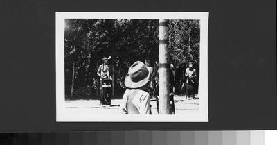 Boy Watches Indian Men in Ceremonial Dress In Performance During a Ceremony