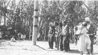 Group Stands in Front of Center Pole of the Lodge During a Ceremony - Pitsuma Taylor, Hugo Bonalsie, Steve Tappay, Carlos Corengo, Morgan Moon, Mary Myers