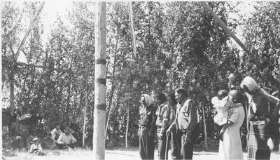 Photo of a group of people including, Pitsuma Taylor, Hugo Bonatsui, Steve Tappay, Carlos Corinjo and Morgan Moon, standing in front of the center pole during a ceremony