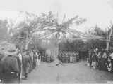 Photo of a large group of people gathered around and inside of the lodge, during a Sun Lodge Ceremony