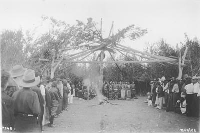 Photo of a large group of people gathered around and inside of the lodge, during a Sun Lodge Ceremony
