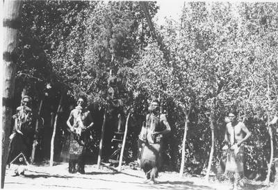 Photo of John Timbana, Star Weed, Bud Le Clair and Louis Enos dancing with feathers in their mouths.